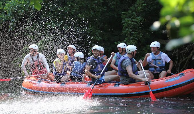 Group white-water rafting on the Cetina River with helmets, life jackets and paddles