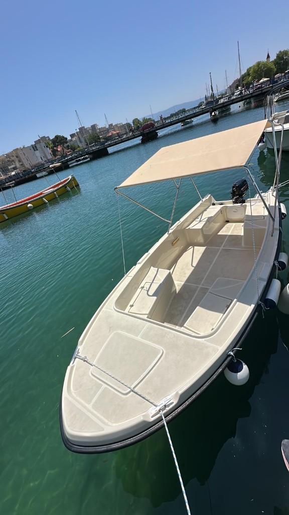 Small motorboat with sunshade docked in a harbor