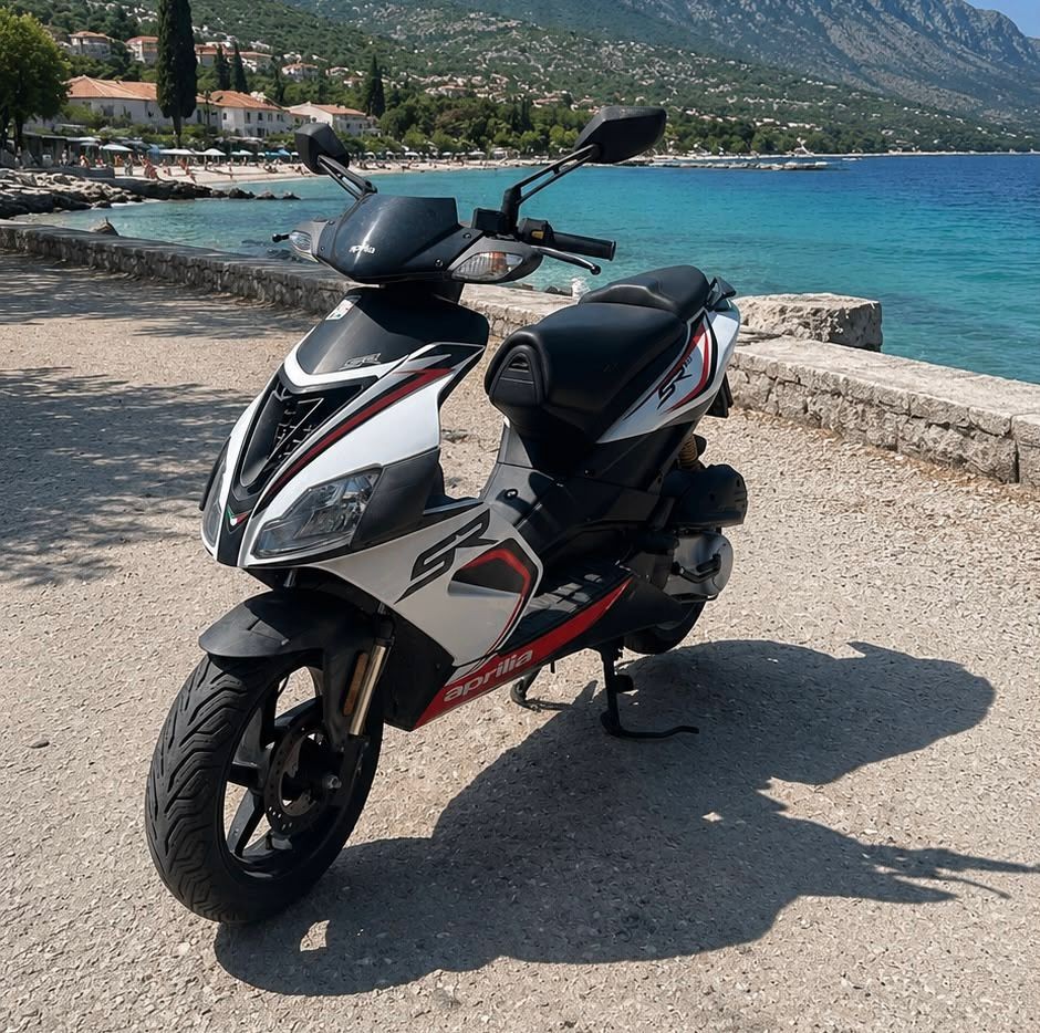 Scooter parked on a coastal path above the Adriatic near Omiš with mountains and sea in the background